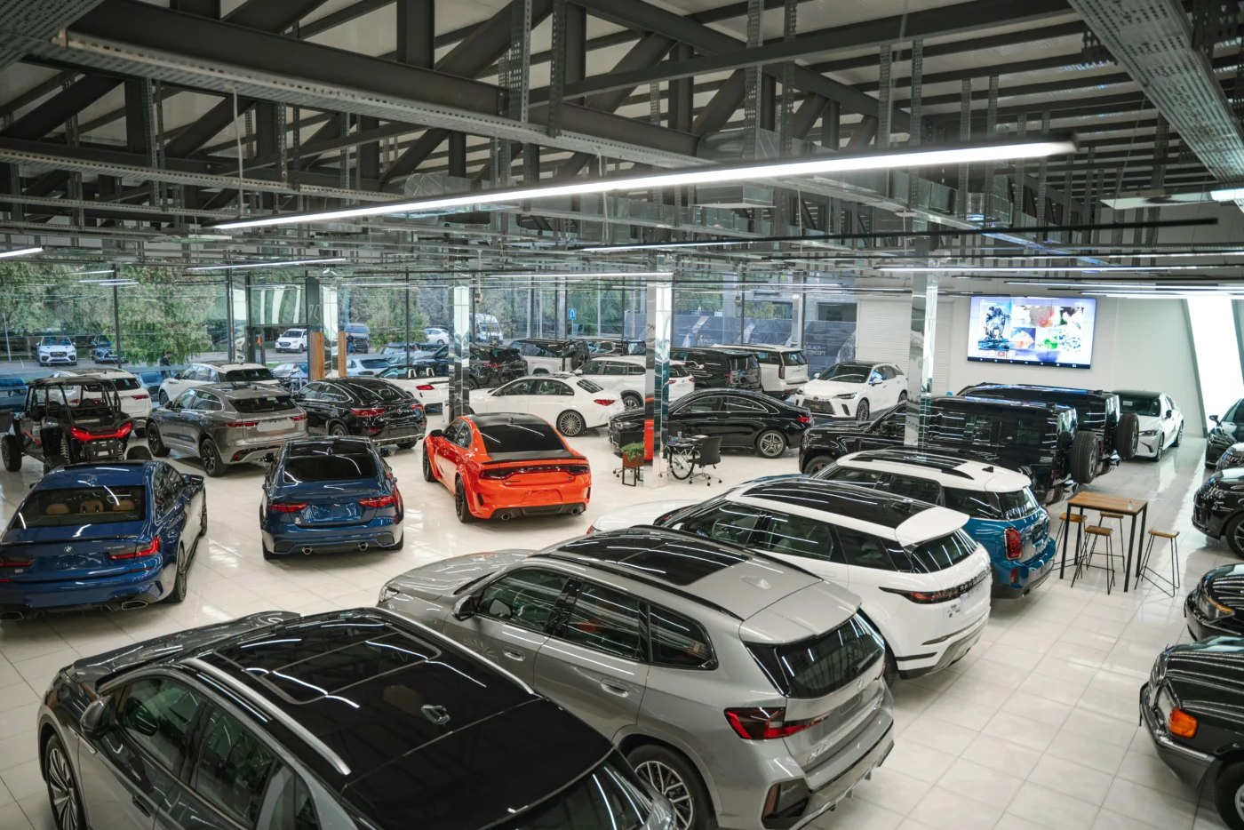 Luxury cars lined up inside a bright showroom